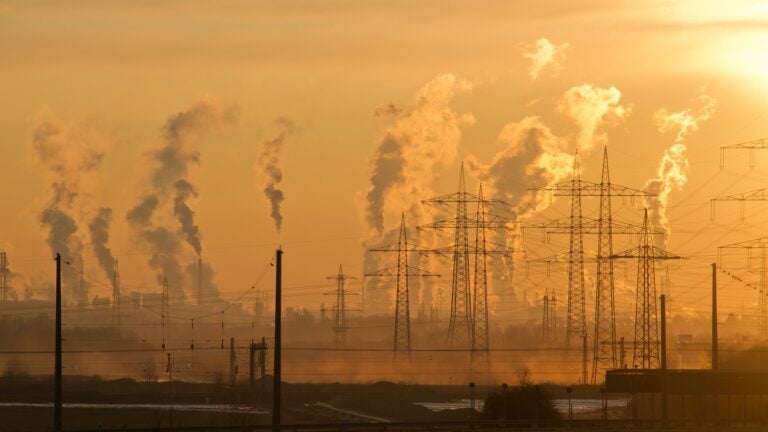 Smokes coming out of smokestacks from factories in the distance.